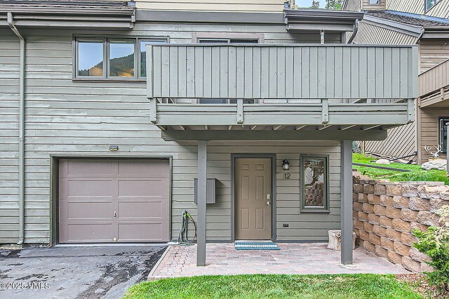 3930 Fall Line Dr Unit 12, Vail, CO 81657 - back of house featuring driveway, an attached garage, a yard, and a chimney
