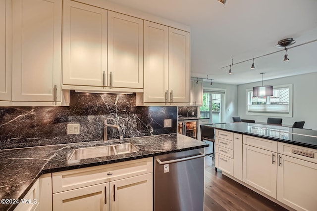 kitchen with dishwasher, pendant lighting, sink, and dark stone countertops