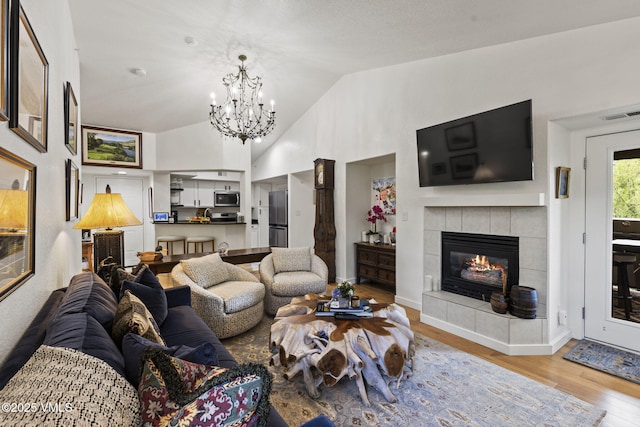 55 River Pines Ct Unit A302, Edwards, CO 81632 - living room featuring light wood-style flooring, a chandelier, a fireplace, and high vaulted ceiling