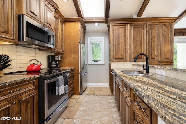 4470 Timber Falls Ct Unit 1407, Vail, CO 81657 - kitchen with appliances with stainless steel finishes, stone tile floors, plenty of natural light, tasteful backsplash, and beam ceiling