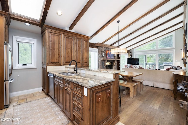 4470 Timber Falls Ct Unit 1407, Vail, CO 81657 - kitchen with open floor plan, stainless steel appliances, a kitchen breakfast bar, light stone countertops, and a peninsula