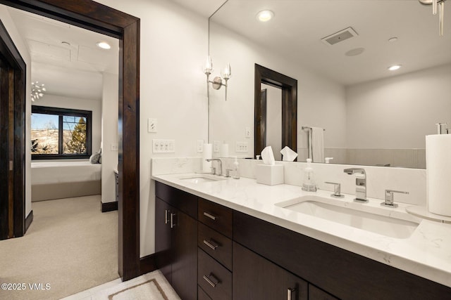 ensuite bathroom featuring a sink, visible vents, recessed lighting, and double vanity