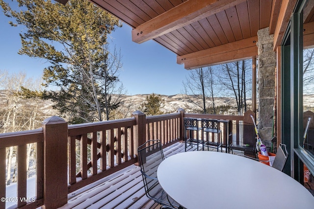 snow covered deck featuring outdoor dining area