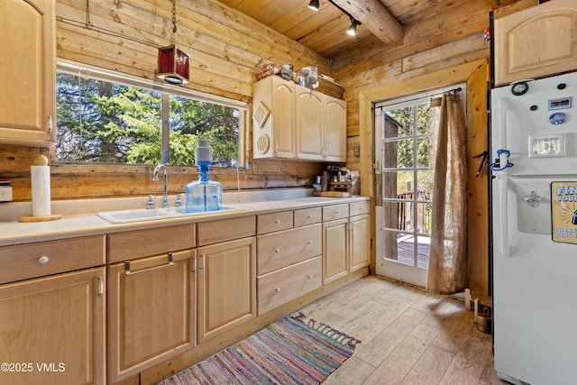 245 Main St, Eagle, CO 81631 - kitchen with freestanding refrigerator, light brown cabinets, a wooden ceiling with exposed beams, track lighting, and wood walls