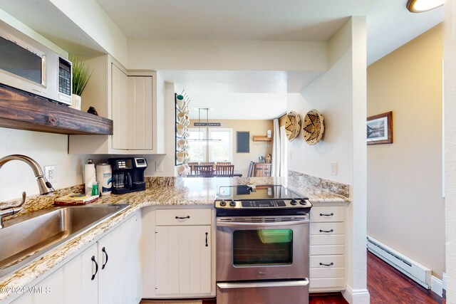 kitchen with stainless steel electric range oven, a baseboard radiator, sink, white cabinets, and light stone countertops