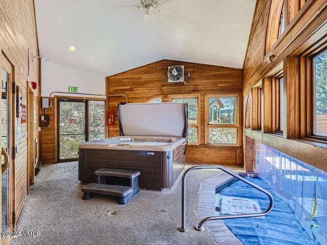 office area featuring light carpet, wooden walls, lofted ceiling, and a healthy amount of sunlight