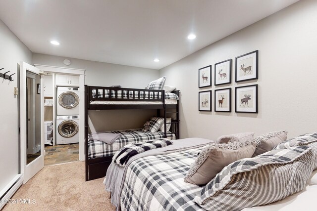 bedroom with a baseboard radiator, stacked washing maching and dryer, and light carpet