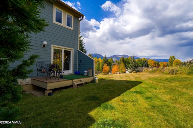 view of yard with a deck with mountain view