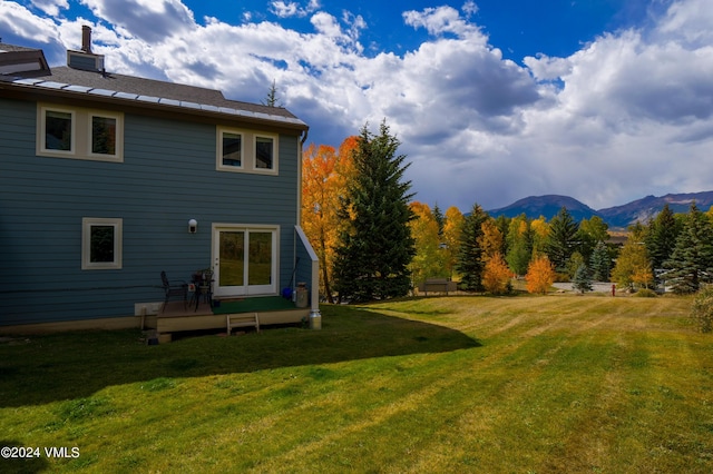 back of house featuring a lawn and a deck with mountain view