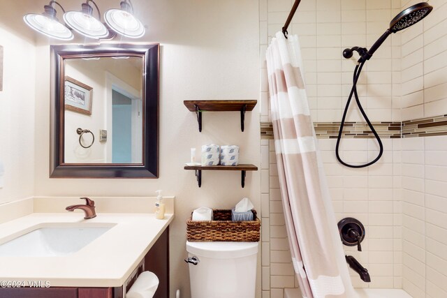 full bathroom featuring shower / bathtub combination with curtain, vanity, and toilet