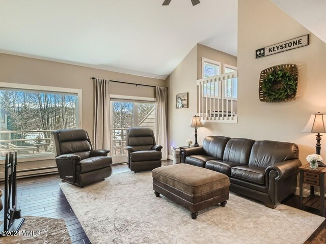 living room with hardwood / wood-style flooring, ceiling fan, and vaulted ceiling