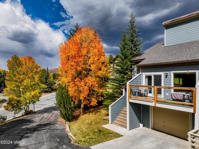 view of side of home featuring a garage and a balcony