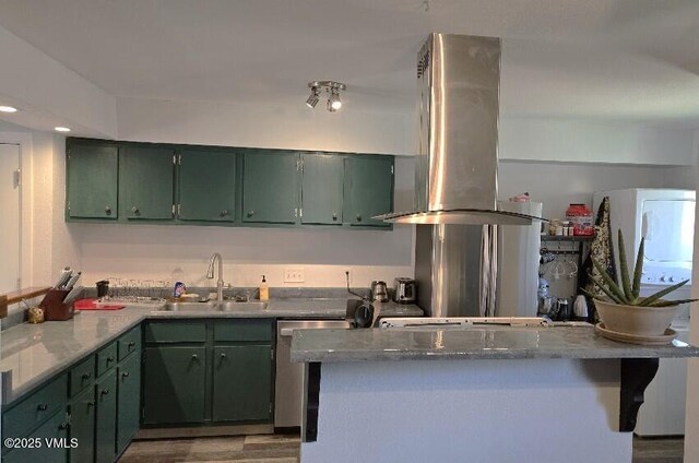 600 Price Ln Unit 6, Gypsum, CO 81637 - kitchen with a sink, green cabinets, island exhaust hood, dishwasher, and wood finished floors