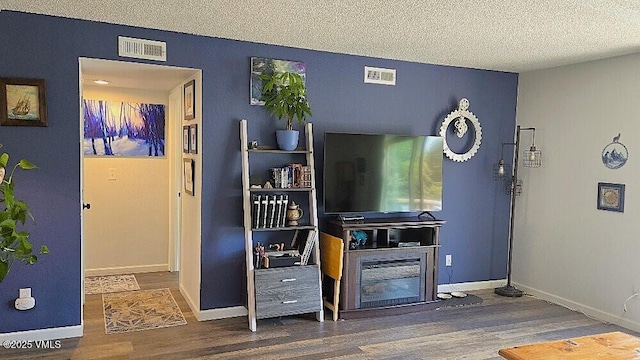 600 Price Ln Unit 6, Gypsum, CO 81637 - living area featuring wood finished floors, a textured ceiling, baseboards, and a glass covered fireplace