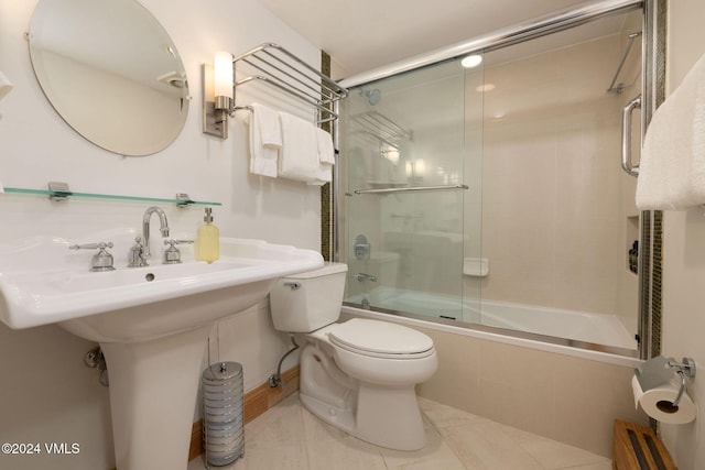 bathroom featuring toilet, tile patterned flooring, and combined bath / shower with glass door