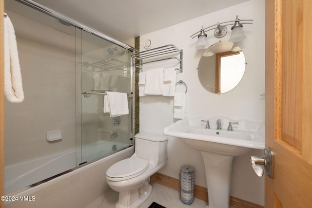 bathroom with enclosed tub / shower combo, tile patterned floors, and toilet