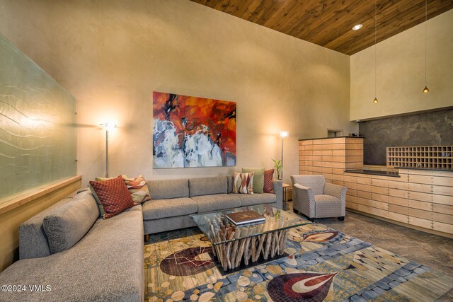 living room with a towering ceiling and wooden ceiling