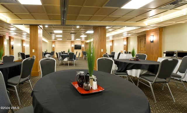 carpeted dining room with wood walls