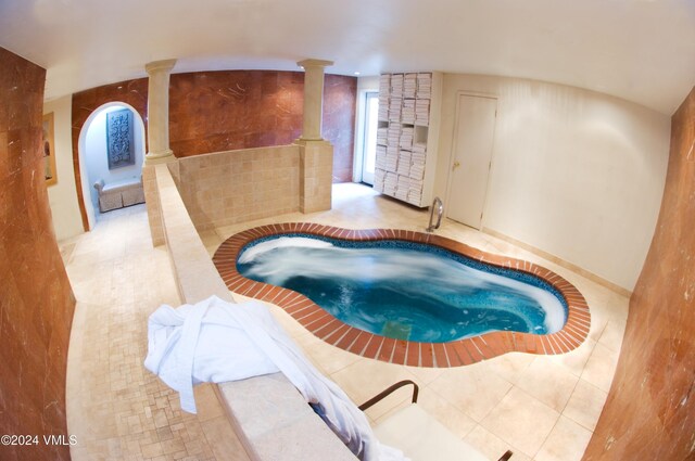 view of swimming pool featuring a hot tub and ornate columns