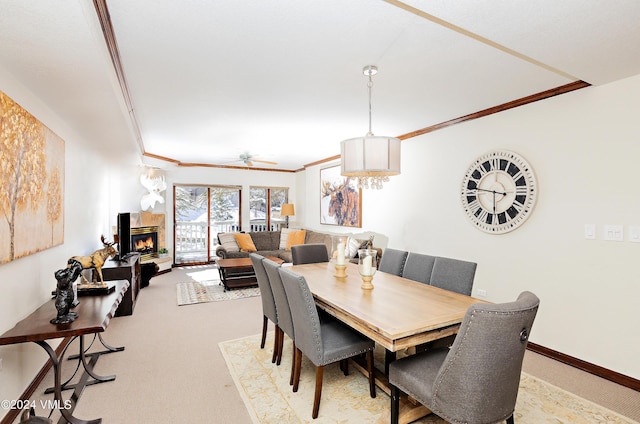 dining space featuring crown molding, light colored carpet, and ceiling fan