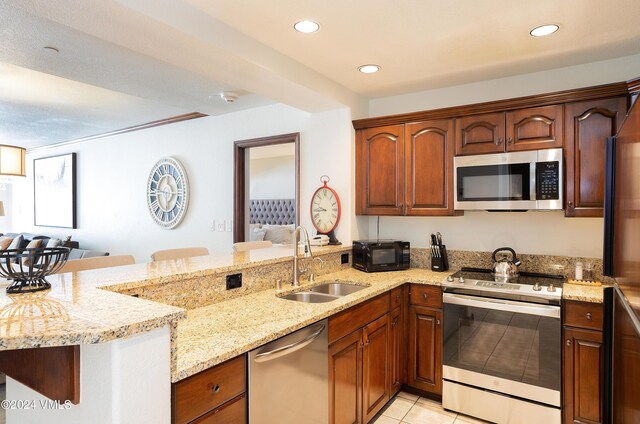 kitchen with stainless steel appliances, kitchen peninsula, and sink