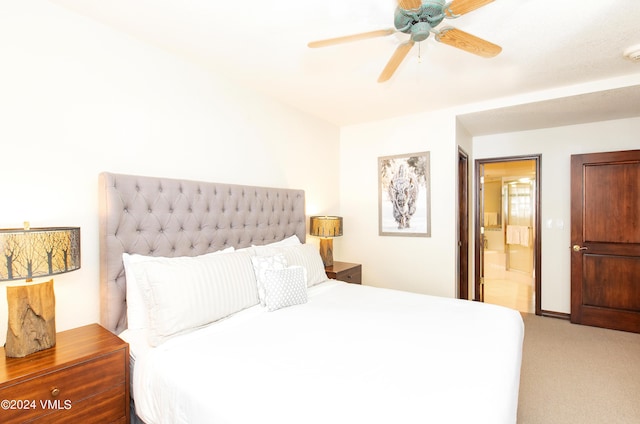 bedroom with ceiling fan, ensuite bath, and light carpet