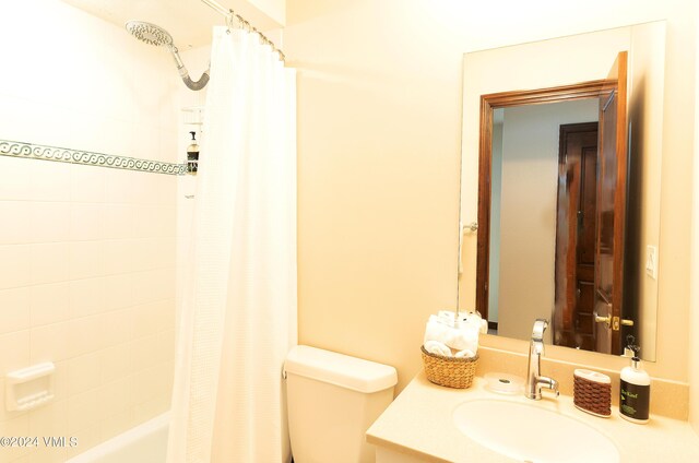 full bathroom with shower / bathtub combination with curtain, vanity, and toilet