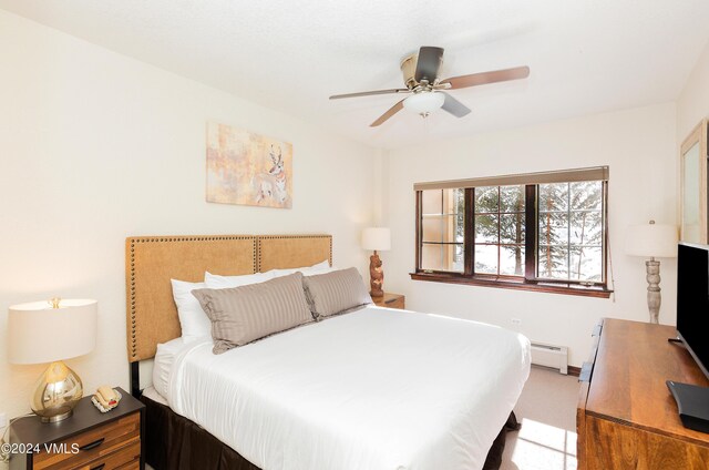 bedroom featuring light colored carpet, ceiling fan, and baseboard heating