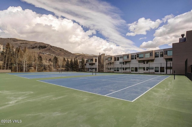view of sport court featuring fence and a mountain view