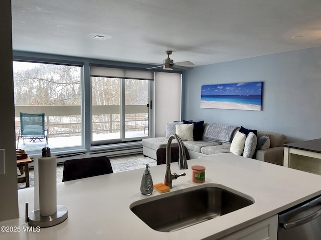 kitchen featuring a ceiling fan, open floor plan, light countertops, a sink, and dishwasher