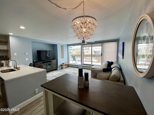dining room featuring baseboards, light wood-style flooring, and a notable chandelier