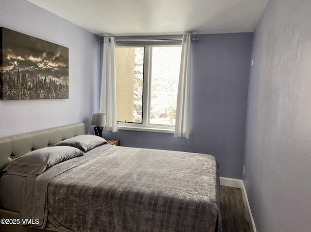 bedroom with baseboards and wood finished floors
