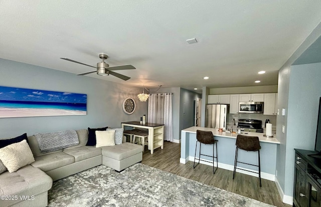living room with a ceiling fan, baseboards, recessed lighting, and dark wood-style floors