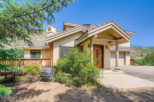 1140 June Creek Rd, Edwards, CO 81632 - view of front of home featuring stucco siding, a garage, driveway, and a wooden deck