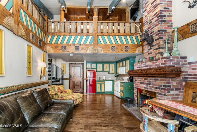 225 Wall St Unit 303, Vail, CO 81657 - living room with a high ceiling, dark wood-type flooring, a brick fireplace, and stairway