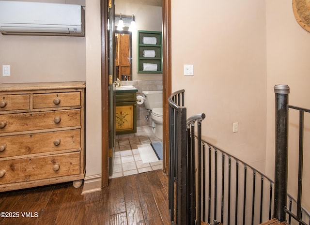 225 Wall St Unit 303, Vail, CO 81657 - bathroom featuring a wall unit AC, vanity, and hardwood / wood-style flooring