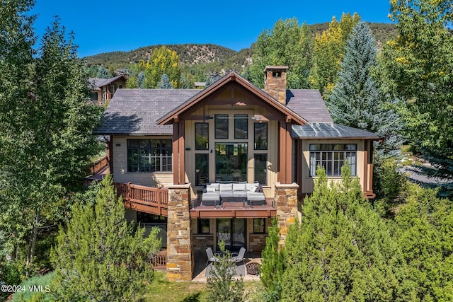 back of property featuring a mountain view and a patio area