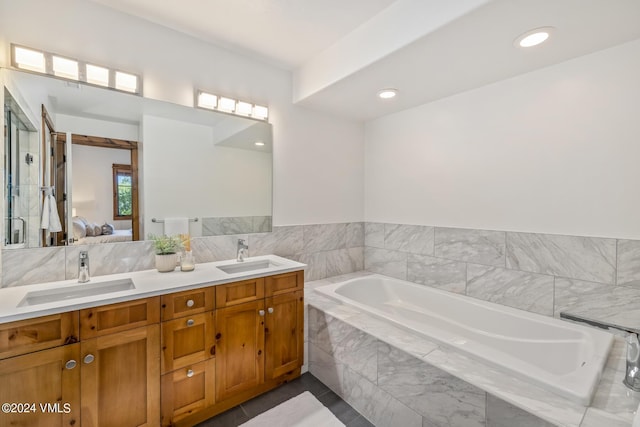 bathroom with vanity and a relaxing tiled tub