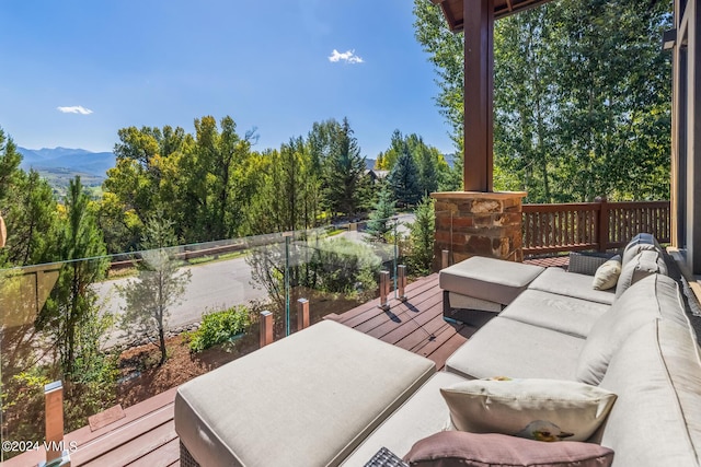 wooden terrace with an outdoor living space and a mountain view