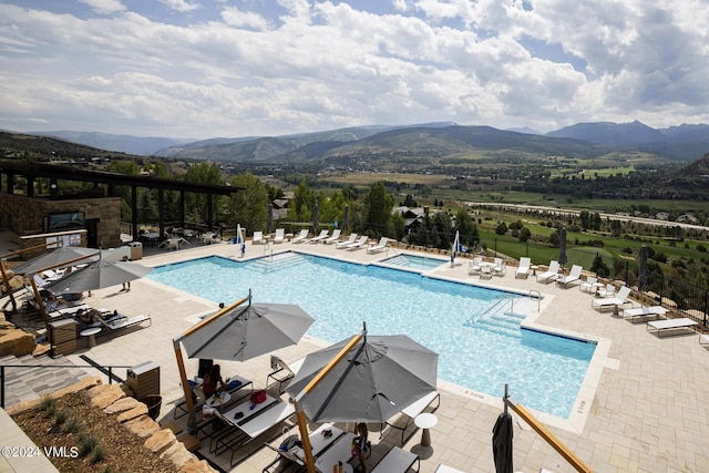 view of swimming pool featuring a mountain view and a patio area