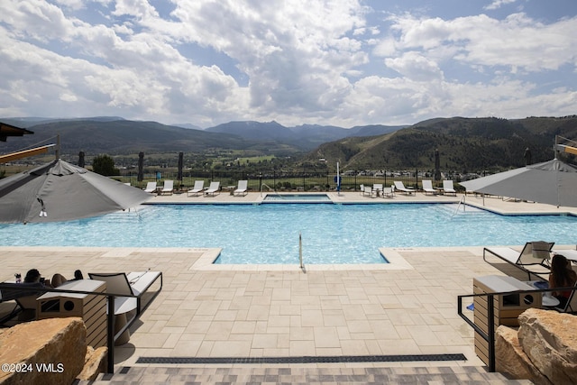 view of swimming pool featuring a mountain view and a patio