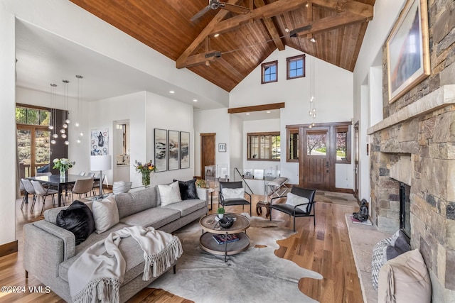 living room featuring wood-type flooring, high vaulted ceiling, wooden ceiling, and a fireplace