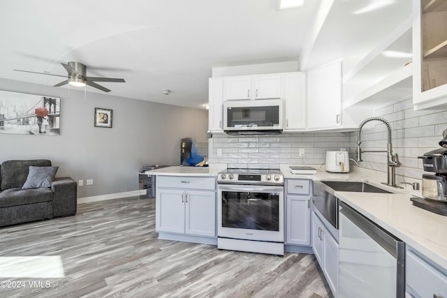 kitchen with tasteful backsplash, sink, stainless steel appliances, and white cabinets