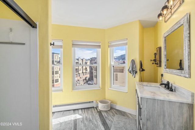 bathroom featuring a baseboard radiator, hardwood / wood-style floors, and vanity