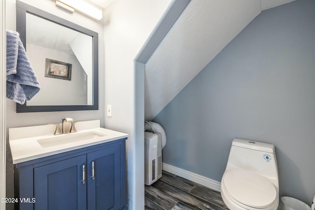 bathroom featuring vanity, lofted ceiling, and toilet