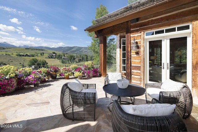 view of patio / terrace featuring french doors, a mountain view, and a rural view