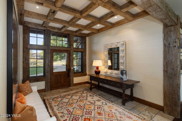 entryway with coffered ceiling, beamed ceiling, and a high ceiling