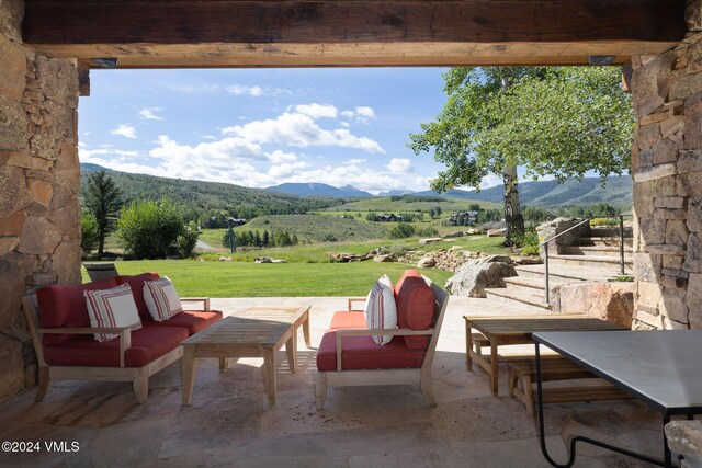 view of patio featuring outdoor lounge area, a mountain view, and a rural view