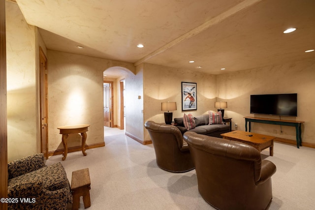 living area featuring light carpet, baseboards, arched walkways, and recessed lighting