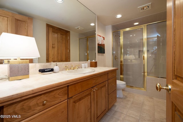 bathroom with recessed lighting, visible vents, toilet, a stall shower, and vanity